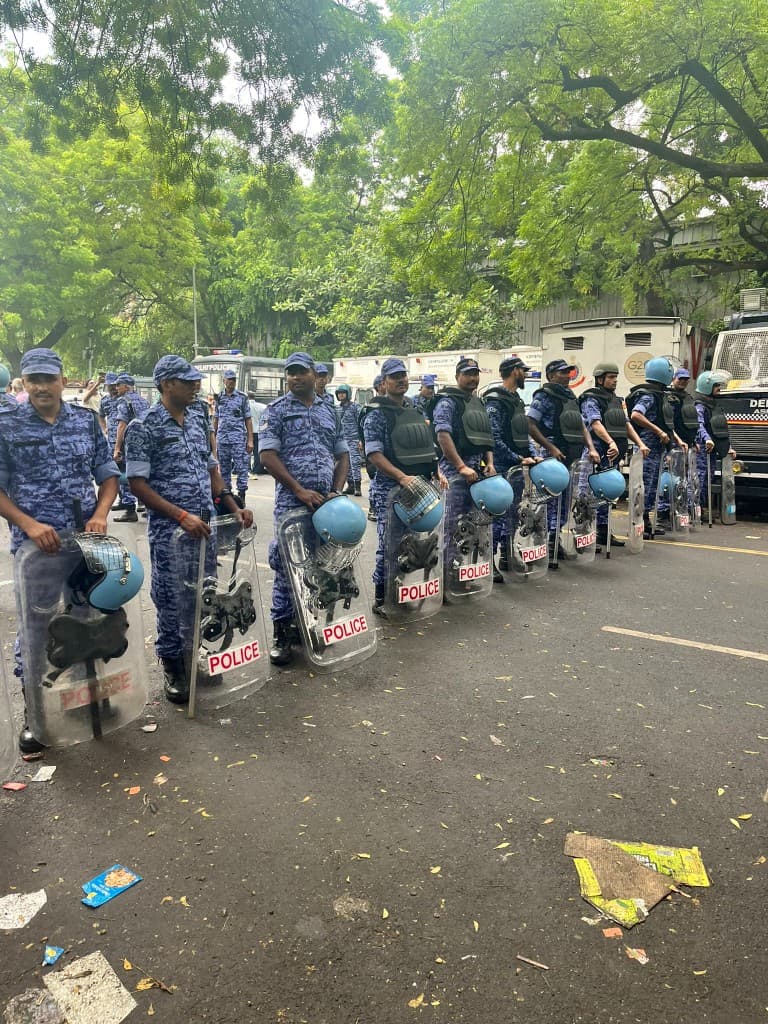 Rapid Action Force officers holding riot shields marked POLICE