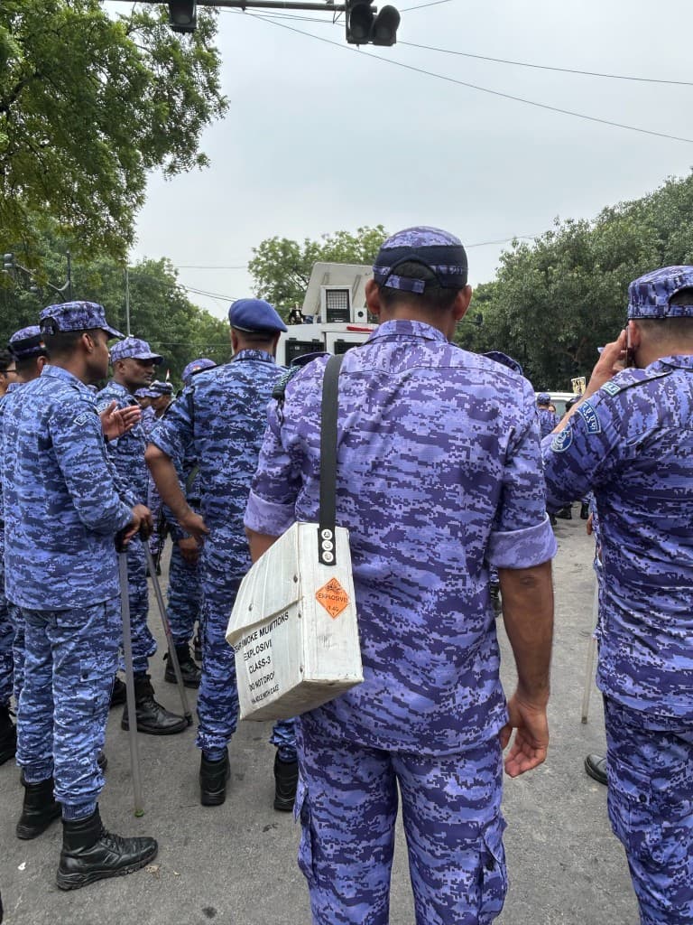 Security personnel carrying a tear smoke munitions box