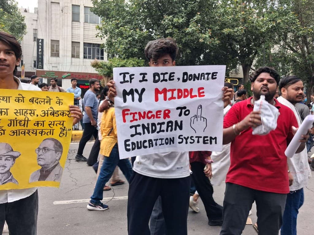 Student holding a protest sign about the Indian education system