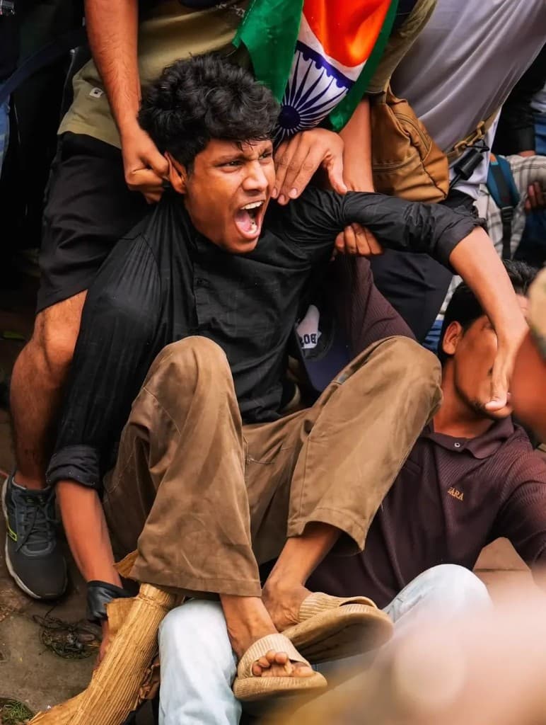 Young protester shouting with the Indian flag behind him